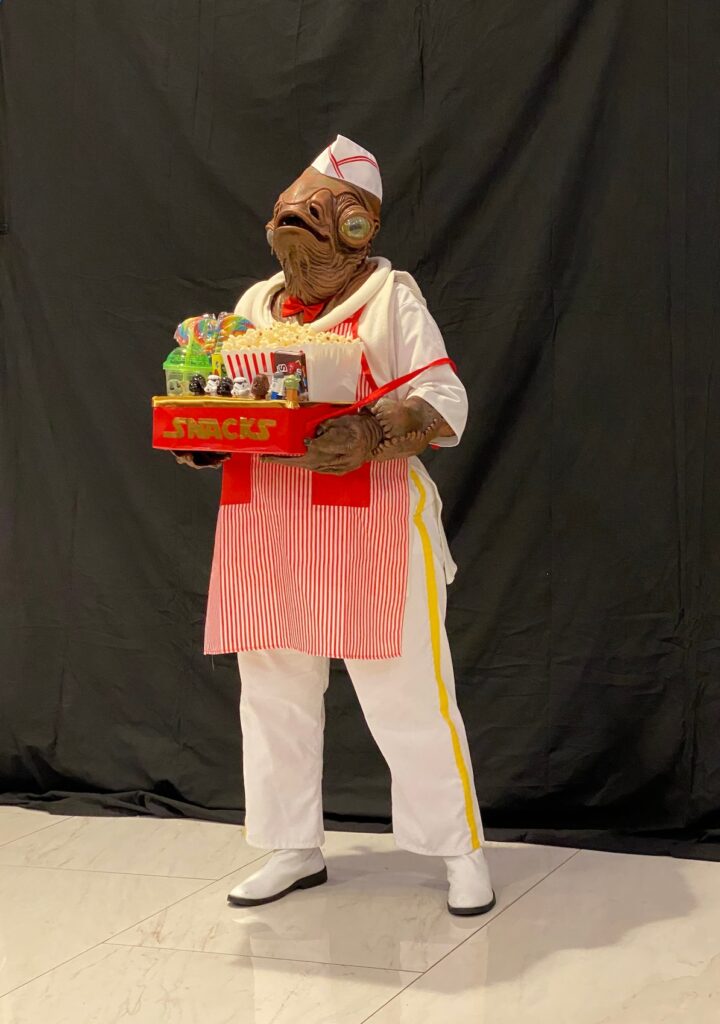 A play on the Star Wars character "General Ackbar", this is the same character, dressed as a theater concessionaire.